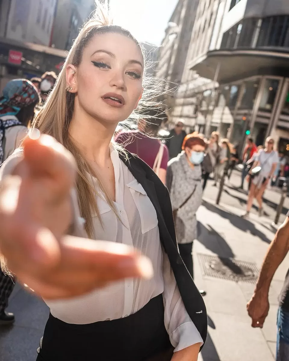 Modelo cruzando Gran Vía de Madrid con un blazer negro sobre los hombros, en plena calle